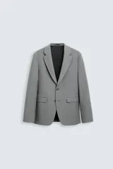 Blazer azul marino de corte recto, confeccionada en tejido con viscosa. Tiene cuello con solapas de muesca, manga larga con puño abotonado, bolsillo de vivo en el pecho y bolsillos de parche en la cadera. El bajo tiene aberturas en la espalda y el cierre es con botonadura frontal.