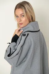 Chaquetón italiano rayado en tonos de natural y negro con vivos en negro. Modelo cruzado que se prende con un botón, amplios bolsillos delanteros y calce holgado.
