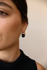 Aros dorados con dije circular de piedra natural negra.