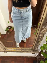 Pollera midi de denim celeste claro, de tiro medio, con bolsillos laterales y traseros, costura frontal central y dobladillo deshilachado.