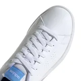 Championes Adidas Advantage de estilo urbano, inspirados en el calzado de tenis. Presentan un diseño minimalista en color blanco con perforaciones laterales que forman las tres bandas características de la marca, lengüeta con etiqueta azul y detalle iridiscente en el talón.
