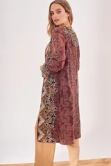 Saco largo abierto con diseño estampado estilo paisley y motivos florales en tonos bordó, negro y beige. Presenta un corte recto y mangas largas.