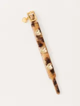 Pulsera regulable de cuero vacuno con estampado animal print, hebilla dorada y dije de corazón dorado. Incluye tres apliques de corazón dorados con la inscripción "jazmin chebar".