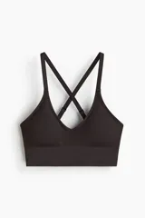 Top deportivo de sujeción media confeccionado en tejido funcional con tecnología DryMove. Presenta diseño sin costuras, textura acanalada, escote en V y espalda con breteles cruzados ajustables. Incluye copas forradas con relleno extraíble y banda elástica ancha en el bajo.