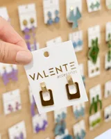 Aros colgantes rectangulares dorados con placa superior y esmalte marrón.
