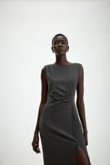 Vestido midi sin mangas de cuello redondo, con detalle de drapeado en el delantero y abertura frontal en el bajo. Cierre posterior con cremallera oculta.