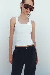 Pantalón de tiro medio color amarillo, con cintura elástica, bolsillos de plastrón en el delantero y pernera holgada que se estrecha hacia el tobillo. Cuenta con cierre frontal de cremallera y botón.