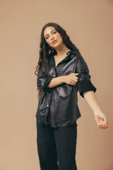 Camisa de cuero color fucsia, de corte recto, con cuello clásico y cierre frontal con botones.