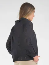 Blusa negra de broderie, con mangas largas abullonadas y cierre frontal de botones.
