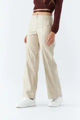 Pantalón marrón de cuero sintético, tiro medio, corte recto cropped y detalle de costuras verticales.