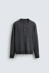 Cárdigan de punto con lana, de corte regular fit, cuello redondo y manga larga. Presenta cierre frontal con botones y acabados en rib en puños y bajo.