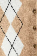 Saco corto de punto jacquard color beige, con estampado de rombos blancos y negros. Tiene cuello redondo, botonadura frontal y ribetes acanalados en puños y bajo.