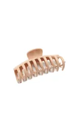 Broche para el pelo tipo clip de garra, en color beige, con diseño de dientes redondeados.