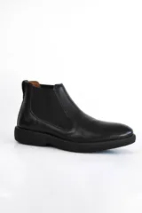 Bota Chelsea de cuero negro con elástico lateral y suela de goma.
