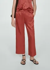 Pantalon de tiro alto con diseño recto y corte crop, confeccionado en tejido satinado fluido con cierre de cremallera y botón.