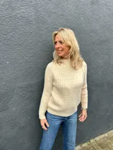 Sweater de tejido de punto color crudo, con diseño de ochos en el frente y punto morley en mangas y espalda. Presenta cuello redondo a la base y mangas largas.