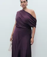 Vestido midi de satén color violeta oscuro, con diseño drapeado en el escote y un hombro al descubierto, de manga corta caída y bajo asimétrico.