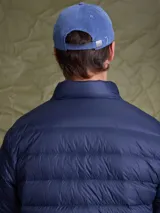 Campera puffer de plumas en color azul marino, con cierre frontal, cuello alto y diseño acolchado horizontal.