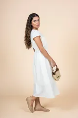 Vestido midi blanco de corte recto con escote redondeado y detalle de frunces. Tiene lazo en la cintura para ajustar la silueta y mangas cortas.