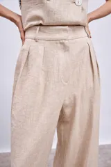 Pantalón de lino color beige, de corte palazzo con pinzas en la cintura.