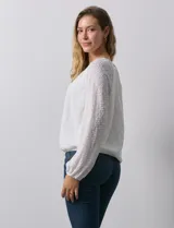 Blusa blanca texturizada, marca Harper, de manga larga con terminación fruncida y ruedo con frunce. Tiene forro interno a tono.