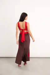 Vestido midi marrón con detalles en rojo, cuello redondo, diseño sin mangas, aberturas cut-out en la cintura y bordados artesanales de flores en contraste.