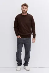 Sweater de punto de cuello redondo, con diseño jaspeado en tono marrón oscuro, de corte clásico y mangas largas con puños acanalados.