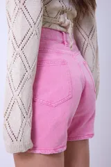 Short de denim rosa de tiro medio con lavado ácido, diseño clásico de cinco bolsillos y trabillas para cinturón.
