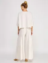 Blusa corta color beige de lino y viscosa, con escote redondo, mangas tres cuartos estilo kimono y corte holgado.