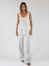 Pantalón de lino blanco de corte recto y holgado, con costuras decorativas verticales al frente.