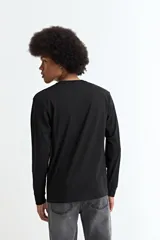 Remera de manga larga con cuello redondo, confeccionada en tejido de algodón y poliéster, con puños elásticos en las mangas.