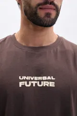 Remera de manga corta color marrón oscuro, corte oversize, con cuello redondo y estampado frontal con el texto "UNIVERSAL FUTURE" en color crema.
