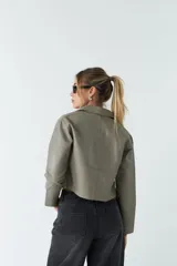 Sobrecamisa de eco cuero con corte cropped, silueta recta y bolsillos frontales con tapa. Presenta cierre frontal con botones y acabado soft.