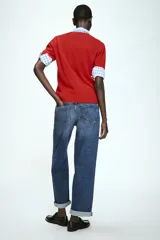 Jeans de tiro alto con corte relajado y pernera recta. Presentan diseño de cinco bolsillos, cierre frontal con cremallera y botón, y terminación con dobladillo en la parte inferior.