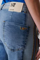 Jean de corte recto y tiro medio, confeccionado en denim con un diseño de lavado en dos tonalidades de azul y detalle de bordado lateral a contratono.