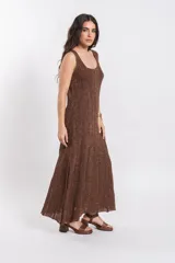 Vestido largo de punto tejido con acabado brillante en tono marrón, sin mangas, con escote redondo y silueta fluida.