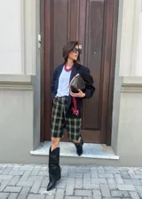 Botas de caña alta negras con punta en pico, taco bajo y detalles metálicos plateados en los laterales de la caña.