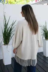 Saco abierto de corte recto y holgado, color visón, con mangas tres cuartos y detalle de flecos largos en el ruedo.