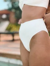 Bombacha de bikini tiro alto, modelo vedetina, confeccionada en tela dry fit de secado rápido con protección UV, color amarillo.
