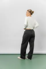 Pantalón deportivo de corte wide leg con caída relajada. Presenta cintura elastizada con cordón ajustable, bolsillos laterales y un interior frizado para mayor abrigo.