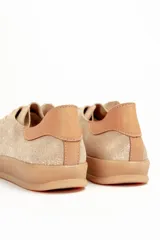 Zapatilla de cuero vacuno color rojo, con cordones al tono y suela de caucho color caramelo. Detalle de cuero vacuno color tostado en el talón.