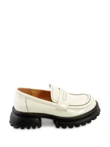 Mocasín color blanco acharolado con detalle de costuras negras y plataforma de goma negra con suela dentada.