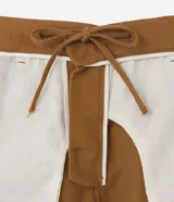 Bermuda masculina de corte recto color marrón, confeccionada en tejido de lino texturizado. Presenta cintura elástica con cordón de ajuste interior, cierre frontal con botón y cremallera, y bolsillos laterales.