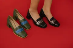 Zapato de cuero verde con aplique de cuero azul y botones forrados.
