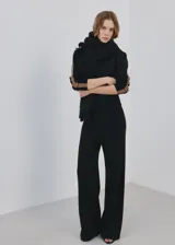 Pantalón de punto negro, de corte ancho y relajado, confeccionado con mezcla de acrílico, poliéster, poliamida y lana.