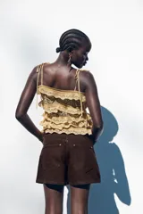 Shorts de jean color marrón oscuro, de tiro medio y corte mom fit. Con cinco bolsillos, cierre frontal con cremallera y botón.