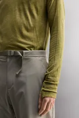 Camiseta térmica de manga larga ranglán, cuello redondo, color verde oliva con efecto tie-dye o jaspeado. Presenta tejido con lana, alta elasticidad y ajuste al cuerpo, con estructuras combinadas para facilitar la transpiración y sin costuras.