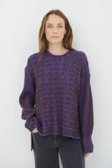 Buzo reversible de tejido de punto con diseño de trenzas, cuello redondo y mangas largas. Presenta una combinación de colores en contraste, con un lado en violeta y el otro en marrón oscuro.