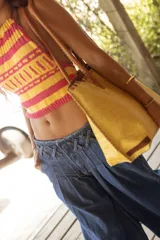 Pantalón wide leg de tiro medio confeccionado en denim, con cintura trabajada con pasacintas entrelazadas, cierre frontal y bolsillos laterales.