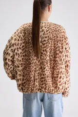 Campera reversible de calce relajado con diseño de animal print tipo leopardo, cierre frontal y bolsillos laterales.